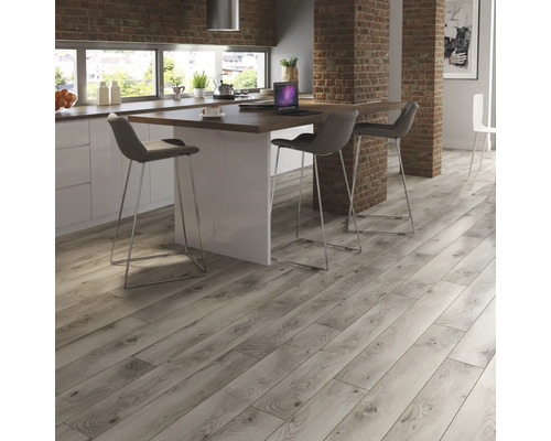 Pardoseală deschisă la culoare, din lemn, într-o bucătărie modernă cu insulă și scaune de bar.