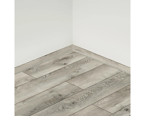 Colțul unei camere cu podea laminată și plintă