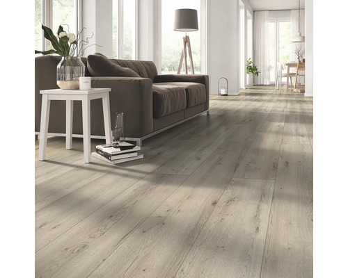 Cameră de zi luminoasă cu parchet laminat, canapea și masă