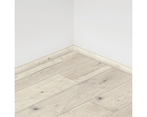 Vedere din colț a unei camere cu podea laminată și plintă