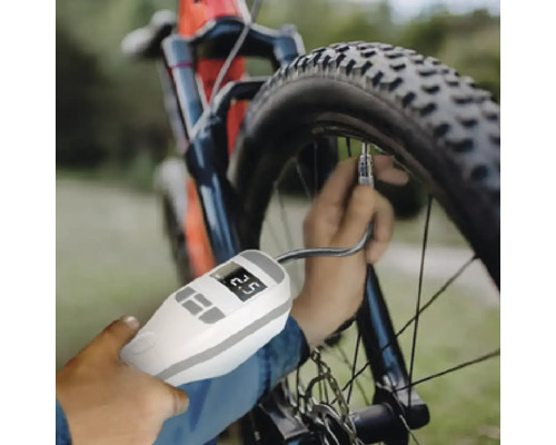 O persoană folosește un manometru digital pentru a verifica presiunea pneului unei biciclete.