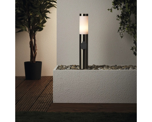 Lumină de exterior pe pietre în jardiniere lângă plante