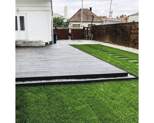 Terasa din lemn cu gazon și pietre de pavaj în grădină.