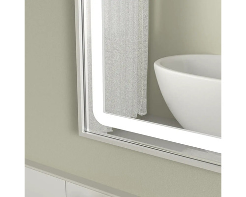 Oglindă de baie iluminată cu design dreptunghiular și colțuri rotunjite.