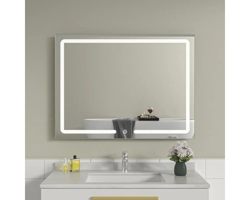 Oglindă dreptunghiulară iluminată deasupra unei chiuvete într-o baie.