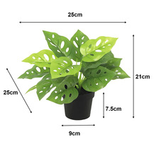Monstera artificială în ghiveci de plastic negru, lățime 25 centimetri, înălțime 21 centimetri, adâncime 25 centimetri.